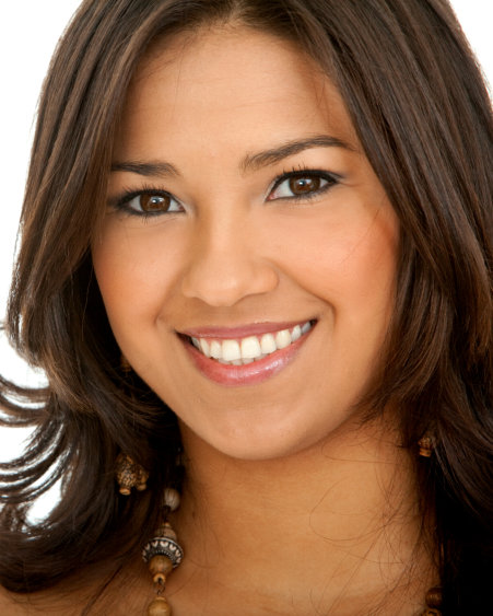 Close-up of a person with medium-length dark brown hair, wearing a beaded necklace and earrings.