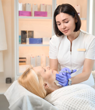 Practitioner administering facial injection to client in a clinic.
